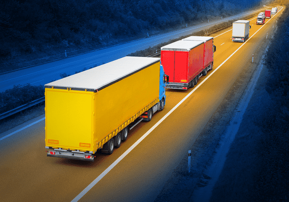 yellow and red trucks driving down the highway